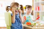 Cute kids eating healthy food in kindergarten or at home